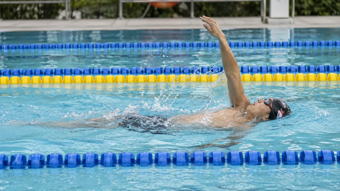 Swimmer doing backstroke with one arm in recovery above the shoulder